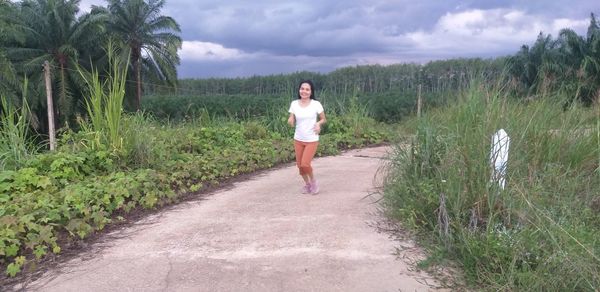 Full length of woman standing on land against sky