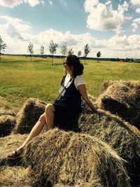 Full length of young woman in field against sky