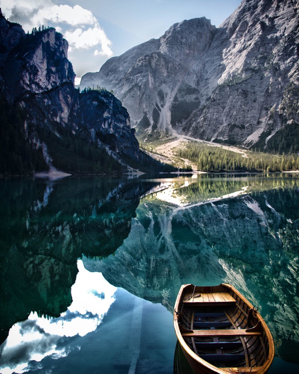 water, reflection, transportation, lake, nautical vessel, mountain, mode of transport, scenics, tranquil scene, boat, tranquility, mountain range, beauty in nature, standing water, non-urban scene, nature, travel destinations, physical geography, rock formation, waterfront, outdoors, tourism, sky, day, calm, majestic, vacations, water surface, remote