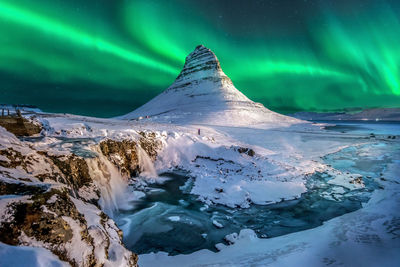 Scenic view of frozen lake against dramatic sky