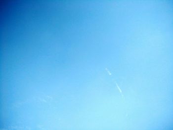 Low angle view of vapor trail against clear blue sky