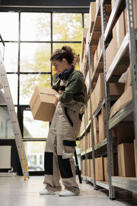 Portrait of young woman standing against building