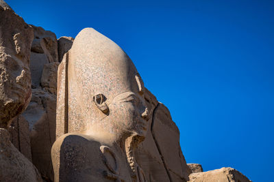 Low angle view of statue against clear blue sky