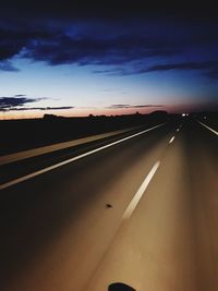 Empty road against sky during sunset