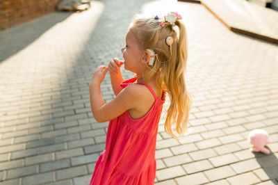 Rear view of young woman holding umbrella