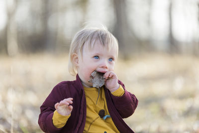Portrait of cute boy blowing outdoors