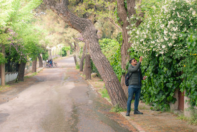 Rear view of man walking on footpath amidst trees