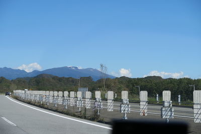 Road by mountains against blue sky