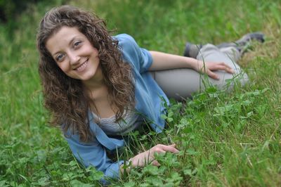 Portrait of smiling young woman lying on grass