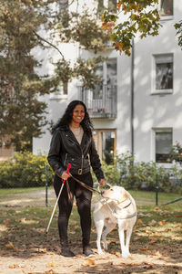 Visually impaired woman smiling and holding guide dog