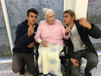 Grandsons showing middle finger by grandmother at home