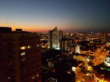 High angle view of illuminated buildings against sky at night