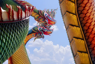 Low angle view of sculptures on roof of building against sky