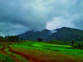 Scenic view of field and mountains against sky