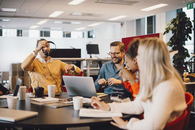 Smiling business colleagues sitting at conference table in office