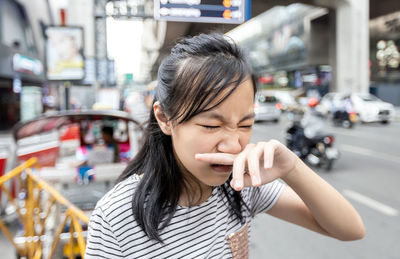 Portrait of beautiful young woman in city street