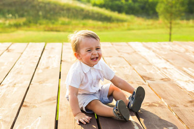 Crying boy sitting outdoors