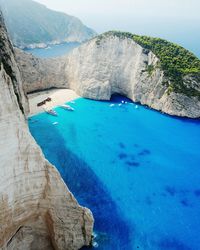 Scenic view of sea and mountains against blue sky