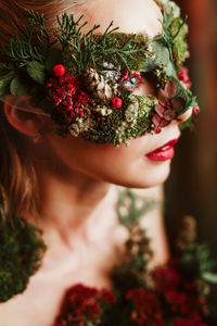 Close-up of woman with flower mask looking away