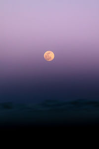 Full moon over the sea waves on the beach