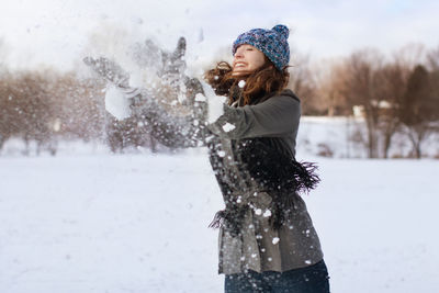 Portrait of young woman standing on snow