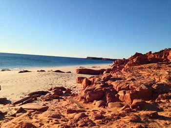 Scenic view of beach against clear blue sky