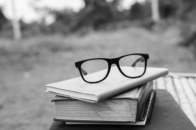 Close-up of eyeglasses on books outdoors