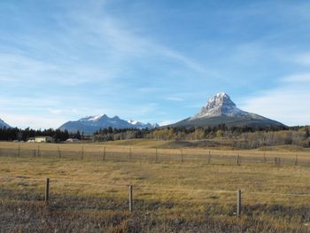 Scenic view of field and mountains against sky