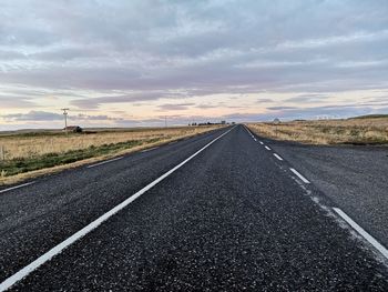 Surface level of road against sky during sunset