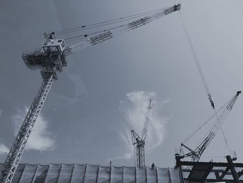 Low angle view of cranes against sky