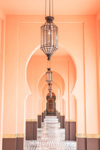 Low angle view of illuminated lights hanging from ceiling in building corridor