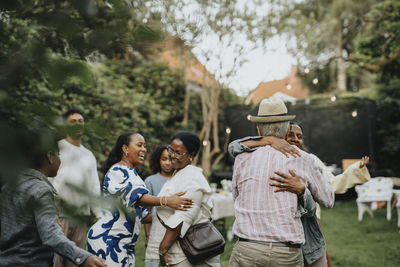 Happy family members greeting each other at garden party