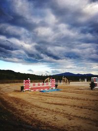 Empty beach against cloudy sky