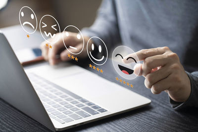 Midsection of woman using laptop on table