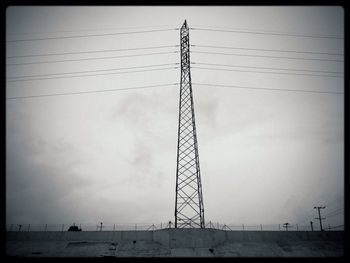Low angle view of electricity pylon against sky