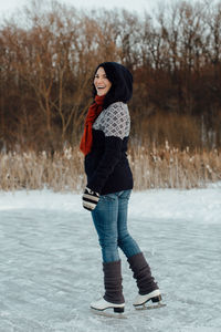 Woman in warm clothing standing on snow