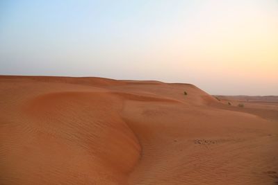 Scenic view of desert against sky during sunset