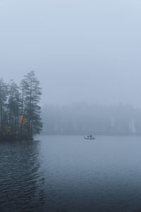 Scenic view of lake against sky during foggy weather