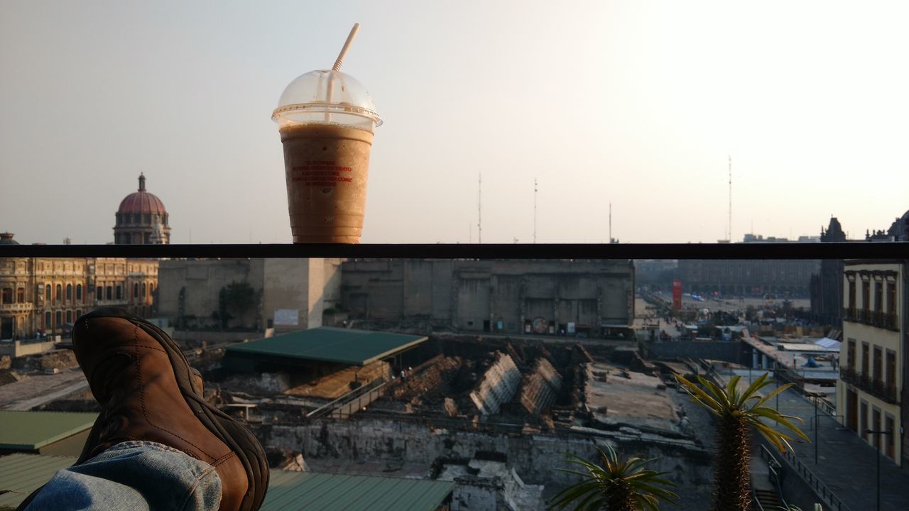 LOW SECTION OF MAN BY BUILDINGS AGAINST SKY