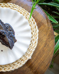 Chocolate cake slice with generous chocolate sauce, a cut piece on a table of a cafe restaurant.