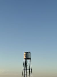 Low angle view of a field water tank against clear sky