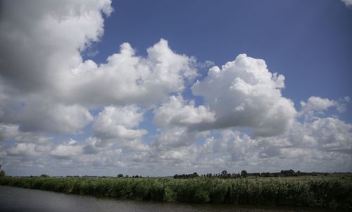 Scenic view of field against cloudy sky