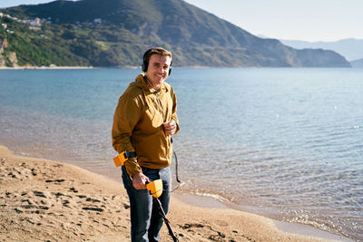 Portrait of young man standing at beach