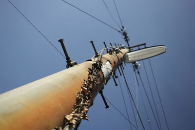 Low angle view of electricity pylon against clear sky