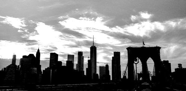 Skyscrapers in city against cloudy sky