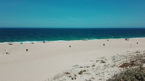 Scenic view of beach against clear blue sky