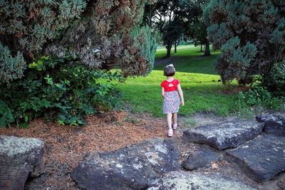 Rear view full length of girl walking at park