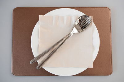 High angle view of fork on table against white background