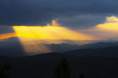 Scenic view of silhouette mountains against sky at sunset