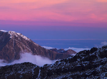 Scenic view of snowcapped mountains against sky during sunset